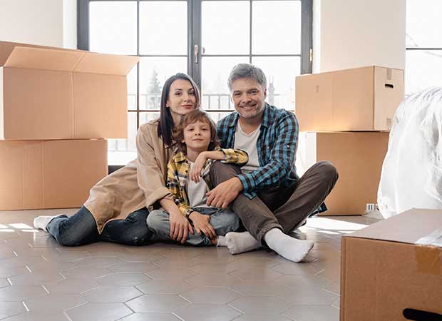 family sitting in a living room surrounded by brown boxes